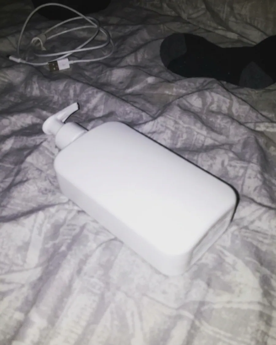 Foto amadora do mesmo frasco jogado na cama, com flash